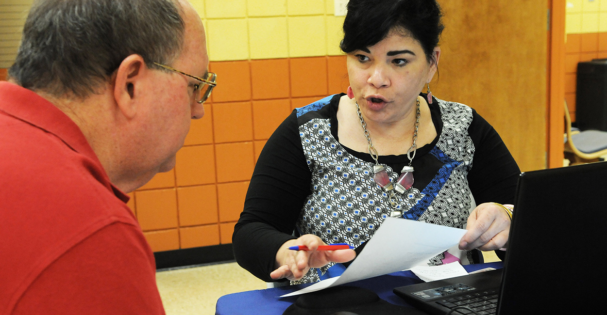 Obamacare navigator Nilda Acosta helps Richard Delph sign up for health insurance under the Affordable Care Act at the Dover Shores Community Center in Orlando. (Photo: Polaris/Newscom)