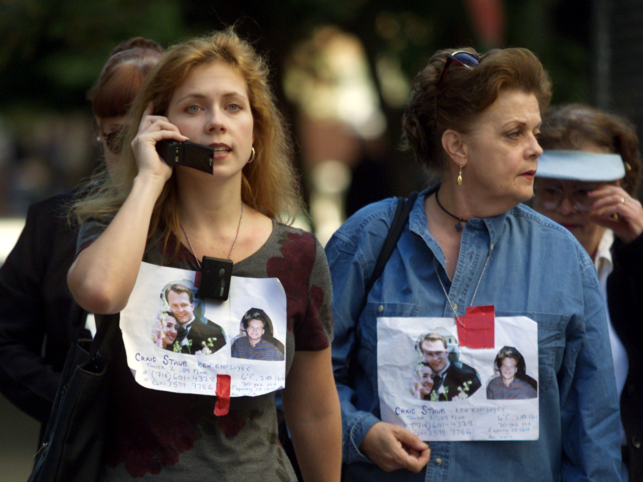 Women wear signs with pictures of missing relatives outside New York's Bellevue Hospital as they wait for word of their fate. (Photo: REUTERS/Shaun Best/Newscom)