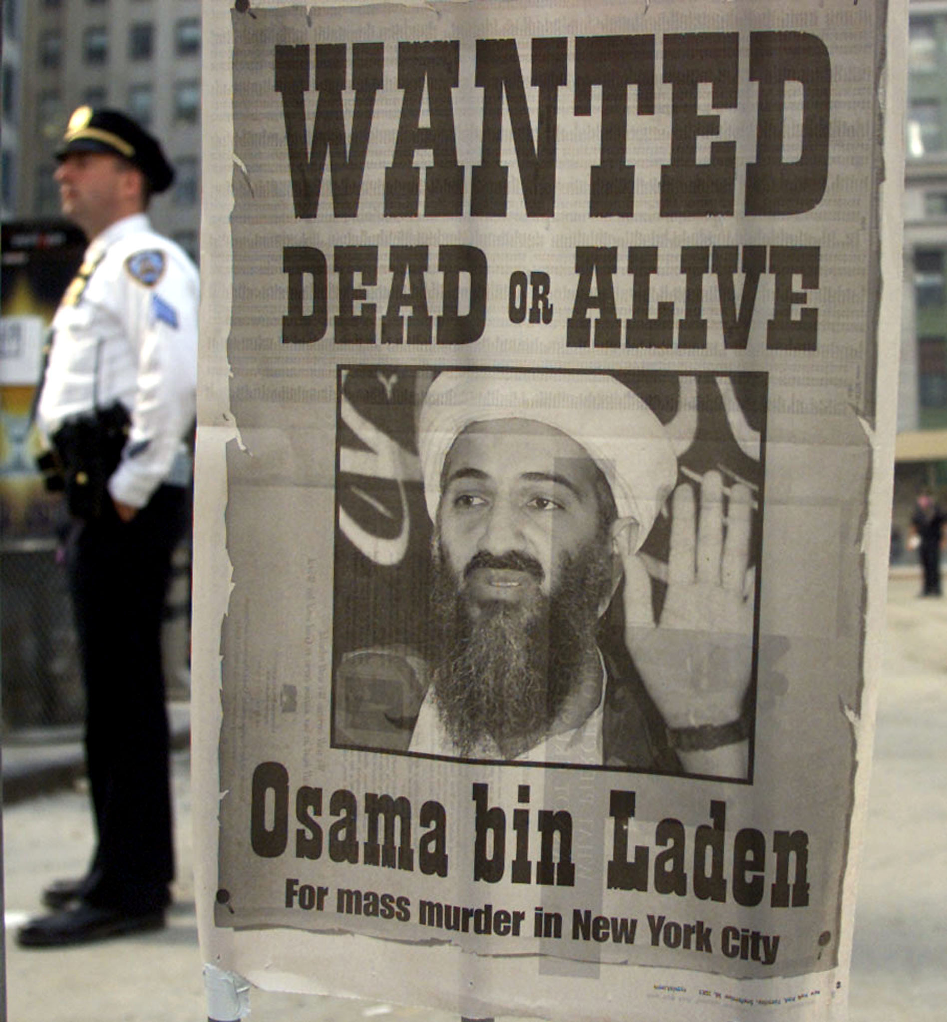 A police officer stands near a 'Wanted' poster for the Saudi-born militant Osama bin Laden in the financial district of New York, September 18, 2001. (Photo: REUTERS/Russell Boyce/Newscom)