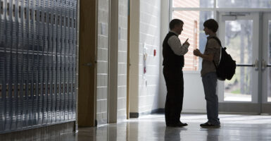 High School Teacher and Student Talking in Hallway