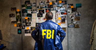 FBI agent in coat looking at wall