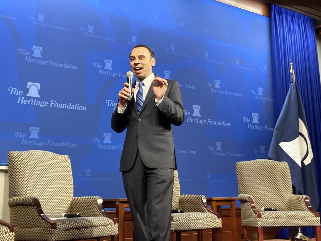 Roger Severino in a gray suit with a blue striped tie speaks at The Heritage Foundation.