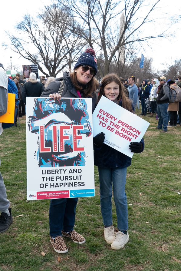 woman and daughter hold signs at March for Life