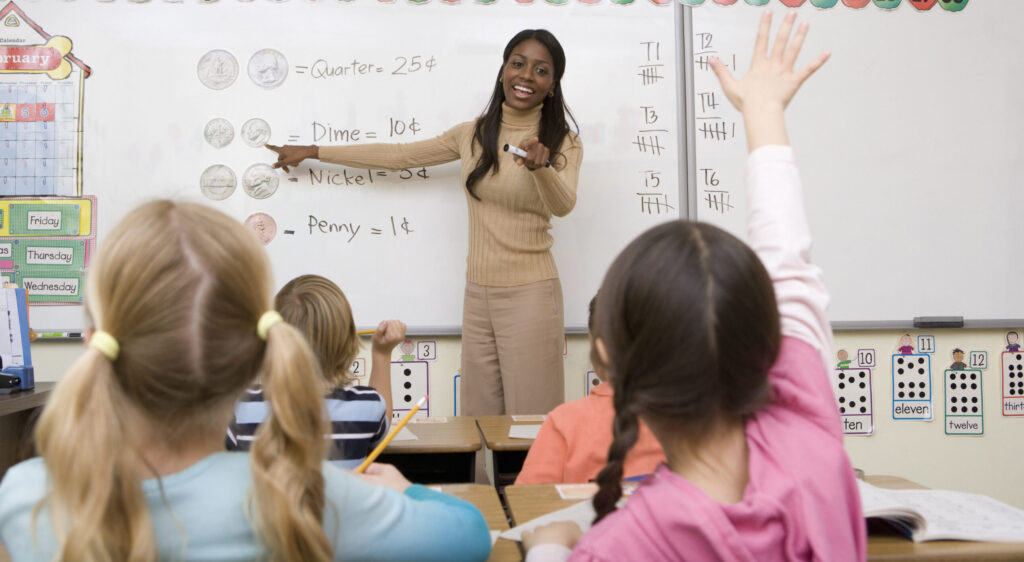 Black female teacher in front of a classroom