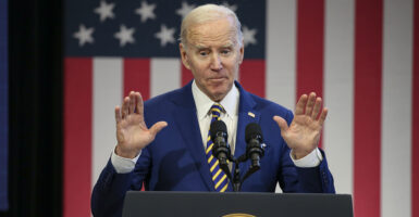 Joe Biden in a suit in front of an American flag