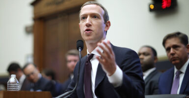 Mark Zuckerberg in a suit gestures