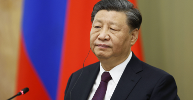Xi Jinping in a suit in front of a red background