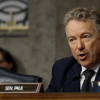 Rand Paul in a suit behind a name tag