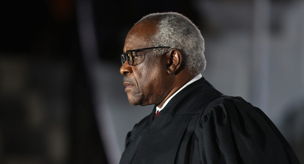 Clarence Thomas with white hair in black robes