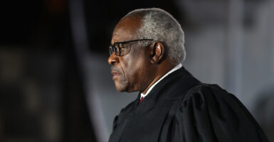 Clarence Thomas with white hair in black robes