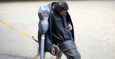 A homeless man loiters Jan. 13 on a sidewalk near San Francisco City Hall.