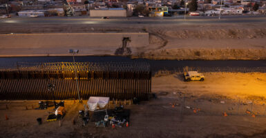 A section of border wall with a gap filled by a short fence on the southern border with Mexico.
