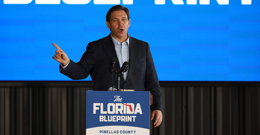 Ron DeSantis speaks at a podium with "The Florida Blueprint" on it