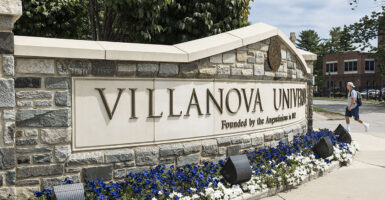 Villanova University sign with purple and white flowers below it
