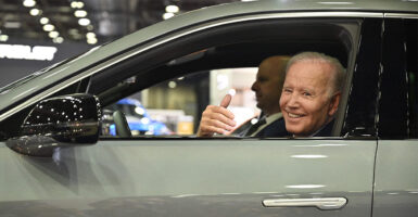 Joe Biden sits at the wheel of an electric vehicle