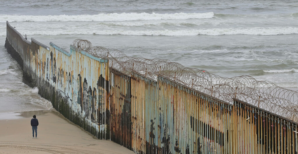 A section of border wall in Tijuana, Mexico is seen jutting out into the ocean.