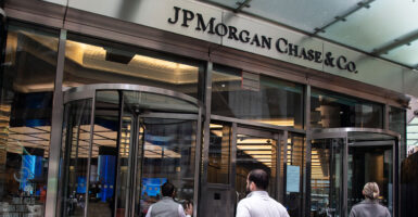 Two men and a woman enter the headquarters of JPMorgan Chase.