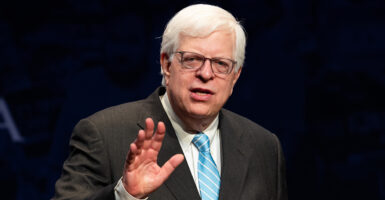 Dennis Prager speaks in a grey pin-stripe suit with a blue tie