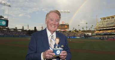 Vin Scully stands with a trophy at Dodgers Stadium