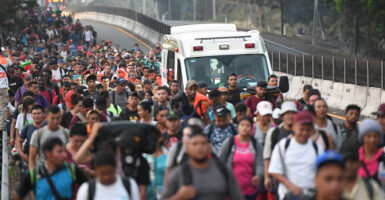 A large caravan of migrant walk on a road in Mexico.