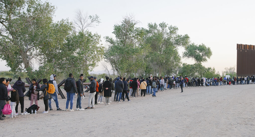 Migrants line up at the U.S.-Mexico border
