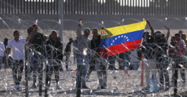 Venezuelan migrants at the border hold a Venezuelan flag
