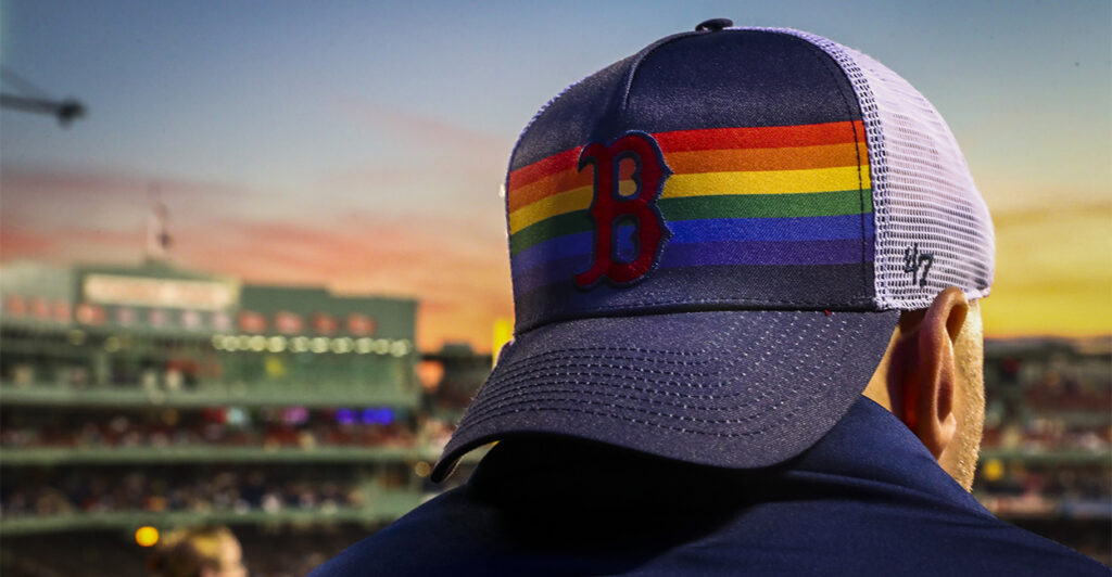 Boston Red Sox fan at a game with LGBTQ pride hat