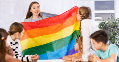 Teacher shows students the LGBTQ+ Pride flag.