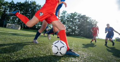 A girl prepares to kick a soccer ball during a soccer game.