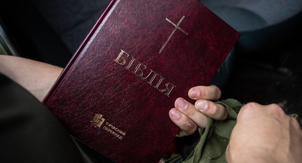 A Ukrainian soldier holds a Bible in Ukrainian
