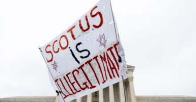 "SCOTUS is illegitimate" banner at the Supreme Court