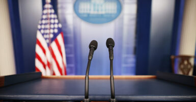 Two microphones stand of a podium in the briefing room at the White House.