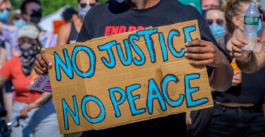 A protestor holding a No Justice No Peace sign