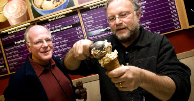 Two men scoop ice cream.