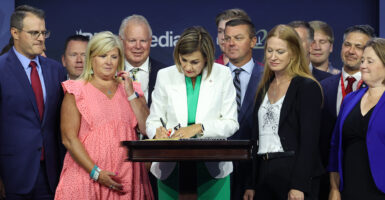 Iowa Gov. Kim Reynolds on stage signing New Six-Week Abortion Ban