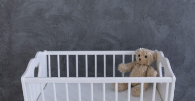 teddy bear in empty crib