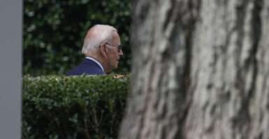 President Biden walking on lawn at White House, looking away