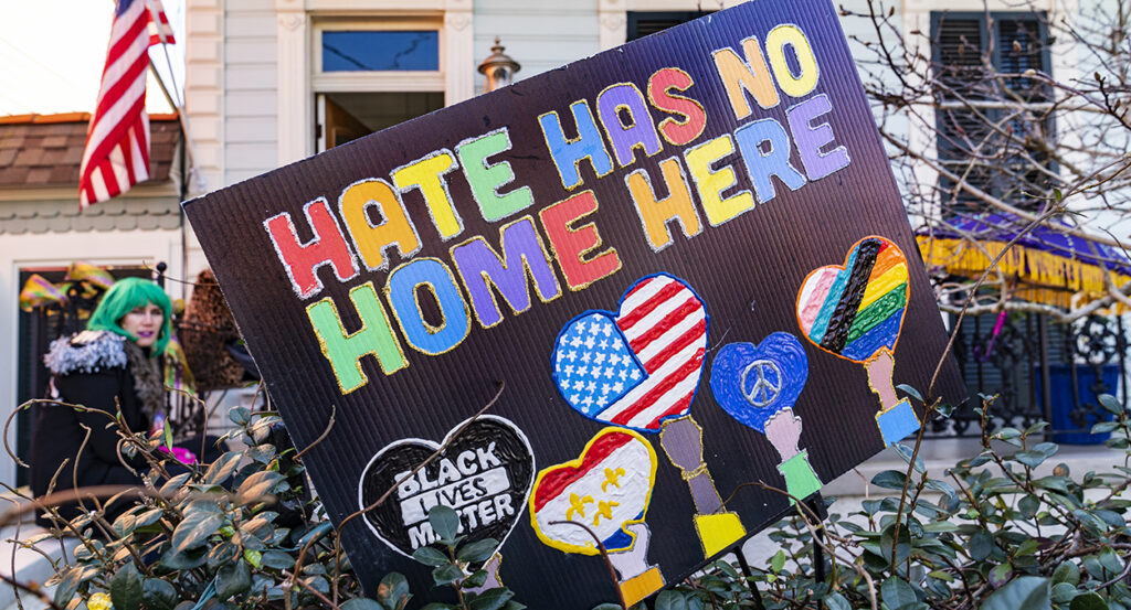 Black sign reads "Hate has no home here" and "Black Lives Matter" in front of a home in New Orleans