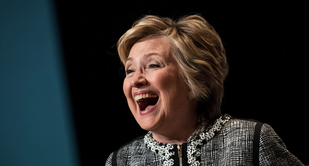 Hillary Clinton laughs in a dress