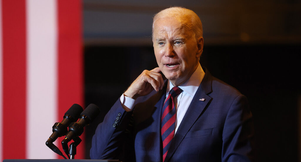 Joe Biden in a blue suit with a striped red and blue tie.