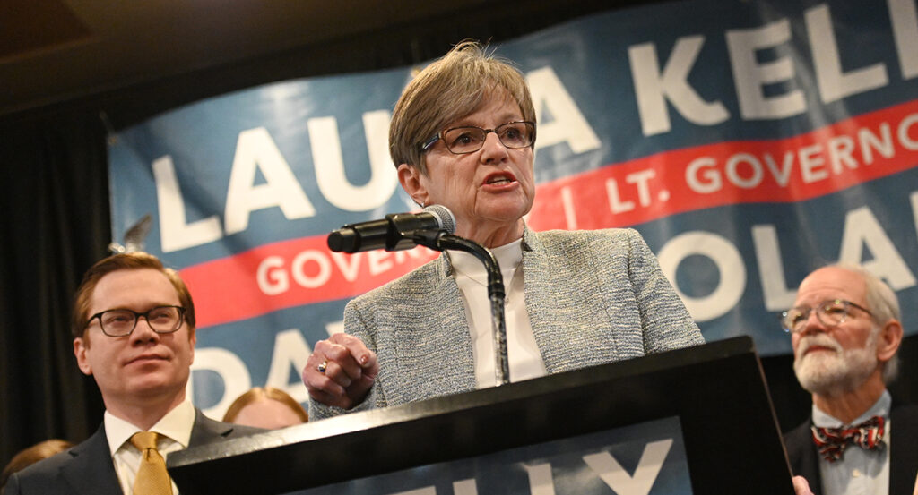 Kansas Governor Laura Kelley speaks in front of a sign with her name on it