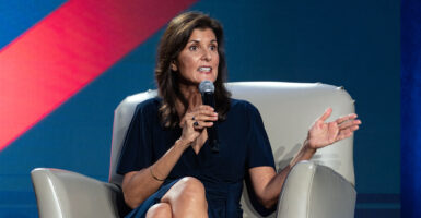 Nikki Haley sits while holding a microphone