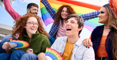 Young people celebrating gay pride festival together outdoors.