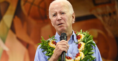 President Joe Biden on stage in Maui with a Hawaiian lei