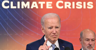 Joe Biden speaking with "climate crisis" on the screen behind him