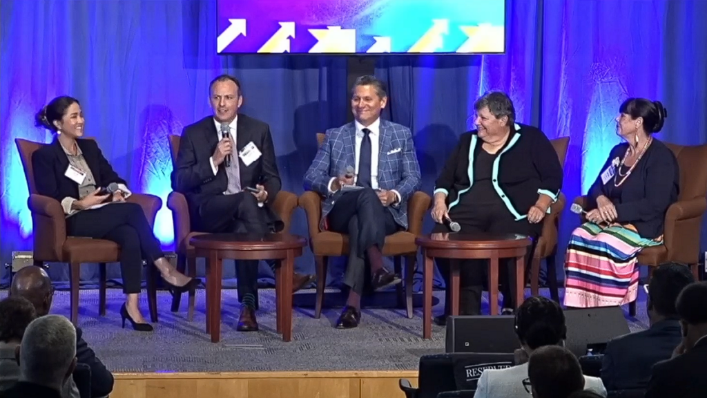 a panel onstage at a department of education summit