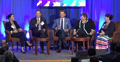 a panel onstage at a department of education summit