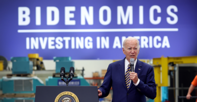 Joe Biden speaks in front of a sign reading 