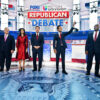 Seven GOP presidential candidates stand together on the debate stage.