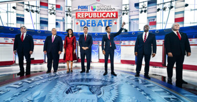 Seven GOP presidential candidates stand together on the debate stage.